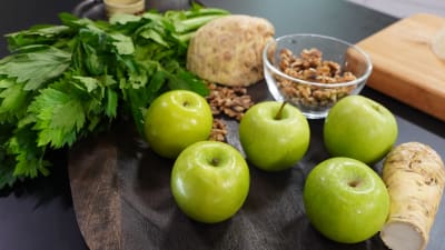 Omenaa, selleriä ja pähkinöitä leikkuulaudalla