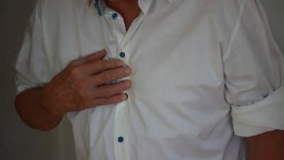 man trycker handen mot bröstet