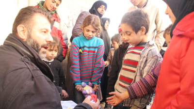 Rami Adham delar ut gosedjur i Aleppo.