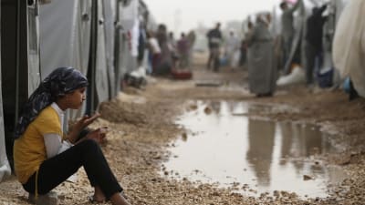 En syrisk flicka sitter utanför sitt tält på ett flyktingläger i Sanliurfa i Turkiet.