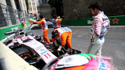 Sergio Perez tittar på då bilen förs iväg