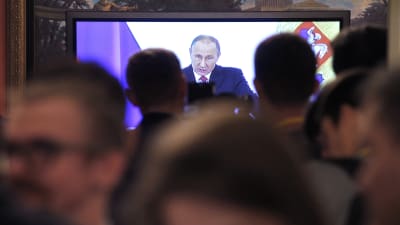 Journalister följer med Putins tal i palatset i Kreml i Moskva.