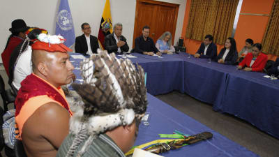 Ett förhandlingsbord; till vänster i bilden syns en delegation från landets urinvånare, i mitten landets president Lenin Moreno.