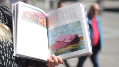 Boken Konst för en stad! uppslagen visandes två färgglada verk av Elina Försti.