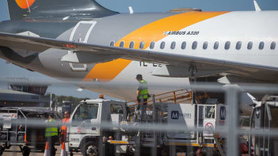 Några män lastar ett Airbus A320-flygplan tillhörande Thomas Cook vid flygplatsen Stansted.