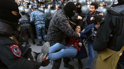 Polisen i Jerevan försöker gripa en demonstrant.
