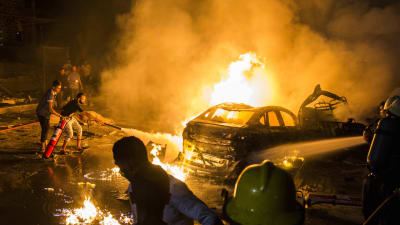 Personer försöker släcka eldsvådan efter en bilexplosion i Kairo.