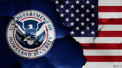 Det amerikanska inrikessäkerhetsministeriet flagga avtecknad på en krackelerad vägg.