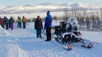 Snöskoter och ett gäng med längdskidåkare i den svenska fjällen.