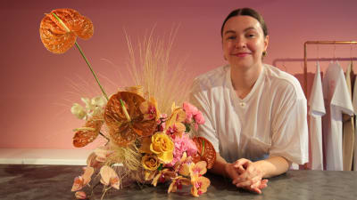 Kuvassa on helsinkiläinen kukkasuunnittelija Viivi Valkeeniemi ja hänen tekemänsä kukka-asetelma.