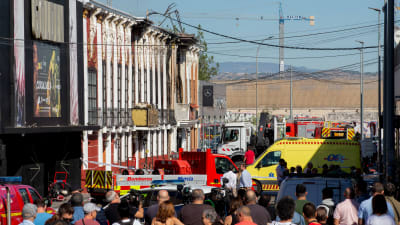 Människor samlades utanför brandkårens avspärrningarna vid den olycksdrabbade nattklubben i Murcia på söndagen.  