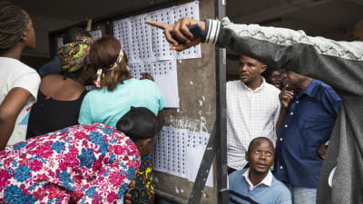 Väljare letar efter sina namn på valrullor i en vallokal i huvudstaden Kinshasa