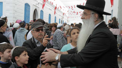En rabbin på besök från Israel välsignar barn från Djerba.