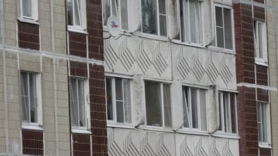 fasaden toilll ett grått ryskt flervåningshus med inslag av rött tegel.