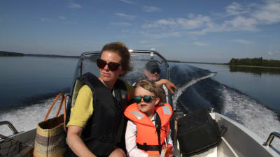 Karin, Amos och Jukka Pennanen i en motorbåt på Puruvesi.
