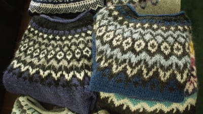 En hög med tröjor med isländskt mönster i olika färger.