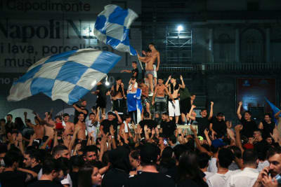 Napolifans firar cupseger i klunga med flaggor.