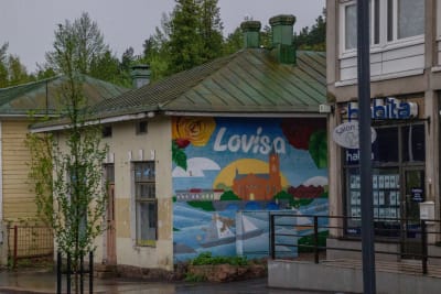 En förfallen fasad, men på ena sidan finns en mural med texten Lovisa
