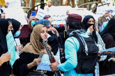Kvinnliga demonstranter stoppas av beväpnade talibaner i Kabul.
