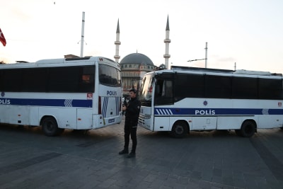 Polisbussar blockerar vägen. Bakom bussarna skymtar en moské.