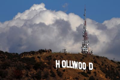 Den kända Hollywoodskylten på avstånd med ett enormt moln bakom.