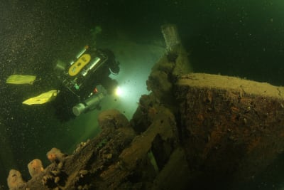 En dykare undersöker ett skeppsvrak från 1700-talet.