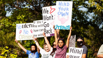 Fyra personer håller upp protestskyltar för aborträtten.