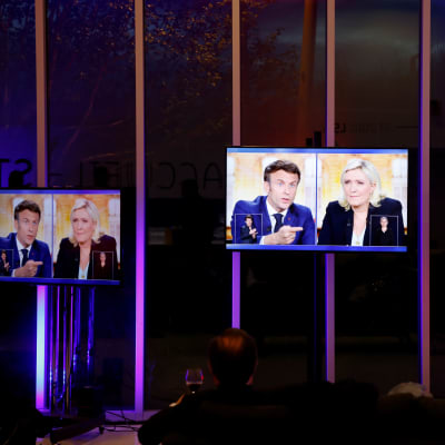 Emmanuel Macron ja Marine Le Pen kolmen tv-ruudun näytöllä.