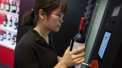 En kvinna testar företaget Alibabas ansiktsigenkänningssystem för köp av alkohol på vinmässan VinExpo i Hongkong våren 2018.