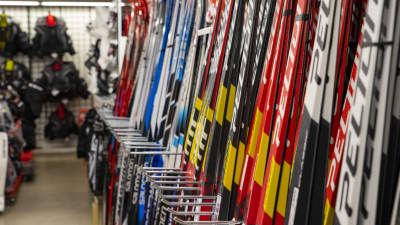 Nya färggranna skidor på rad i en hylla i en sportaffär.