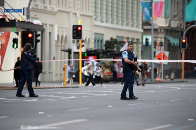 Polisen står och bevakar på gatan i Auckland. 