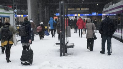 Paikallisjunia Helasingin rautatieasemalla, matkustajia