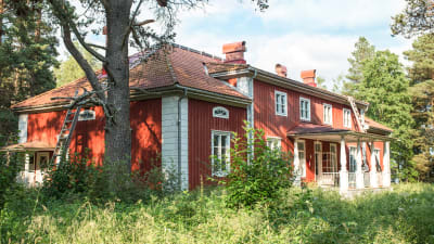 Varjakansaaren vanhan sahakylän päärakennus, punavalkoinen kaksikerroksinen puutalo, edessä kuisti.