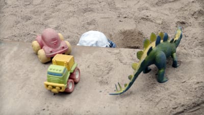 Lapsi leikkii hiekkalaatikolla.