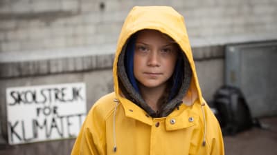 Skoleleven Greta Thunberg i gul regnrock utanför Sveriges riksdag skolstrejkar för klimatet. 2018.