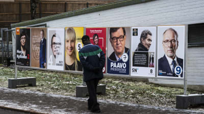 Mies katselee vaalimainoksia