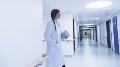 En kvinnlig läkare i en sjukhuskorridor.