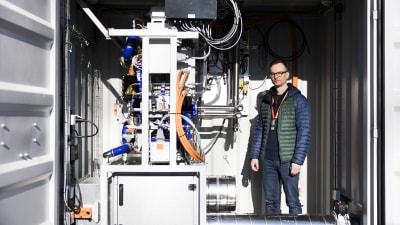 VTT:s laboratorium där man undersöker vätgasproduktion. Antti Arasto syns på bilden tillsammans med en anläggning som har många ledningar och slangar. Otnäs.