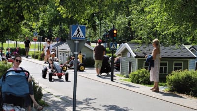 Trafikparken i Äventyrsparken. Barn kör trampbilar mellan miniatyrhus och på en miniatyrväg.