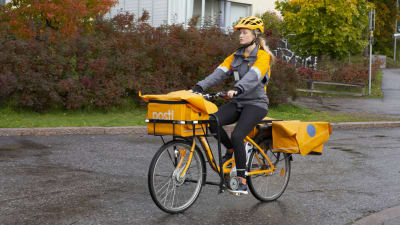 Sara Luostarinen delar ut post på cykel i Böle i Helsingfors. 