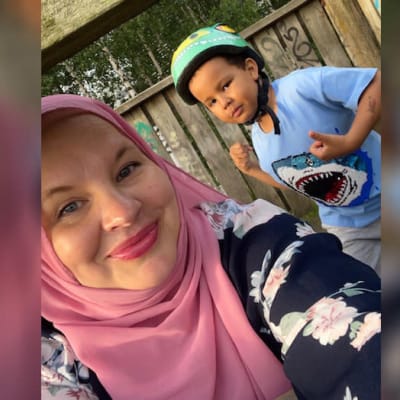 Hijabiin pukeutunut nainen ottaa kuvan itsestään ja kouluikäisestä pojasta.