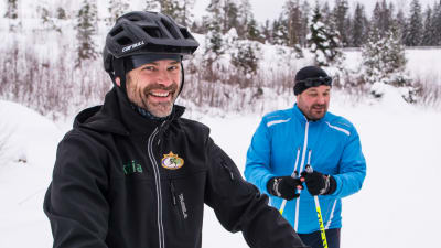 john björkskog med cykelhjälm och markus lindroos med skidor i skidspåret