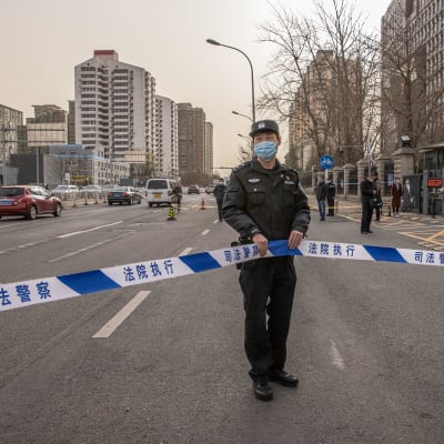 En polis står utanför en domstolsbyggnad i Kina