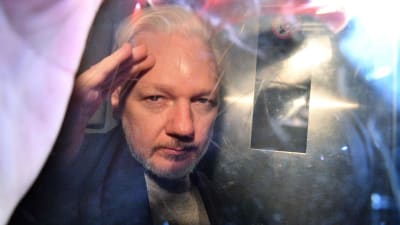Julian Assange gestikulerar till fotografer då han lämnar domstolen i London den första maj 2019, efter att ha dömts till 50 veckor i fängelse. 