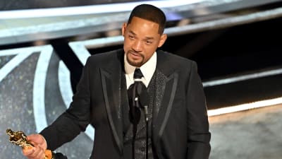 Will Smith står med sin Oscarsstatyett i handen och talar i en mikrofon.