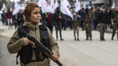 En kvinnlig kurdisk soldat vaktar en begravning i Qamishli