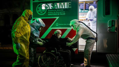 Ambulanspersonal flyttade äldre coronasmittade patienter från ett mentalsjukhus till andra sjukhus i Buenos Aires på söndag kväll. 
