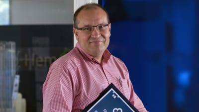 en medelåldersman i rödvit rutig kragskjorta med glasögon.