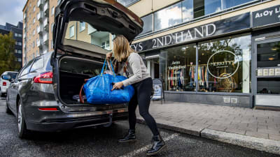 Minaa Seppälä plockar ut begagnade kläder ur bilen som hon ska sälja 