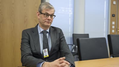 Pasi Tuominen ulkoasiainministeriöstä istuu pöydän ääressä.